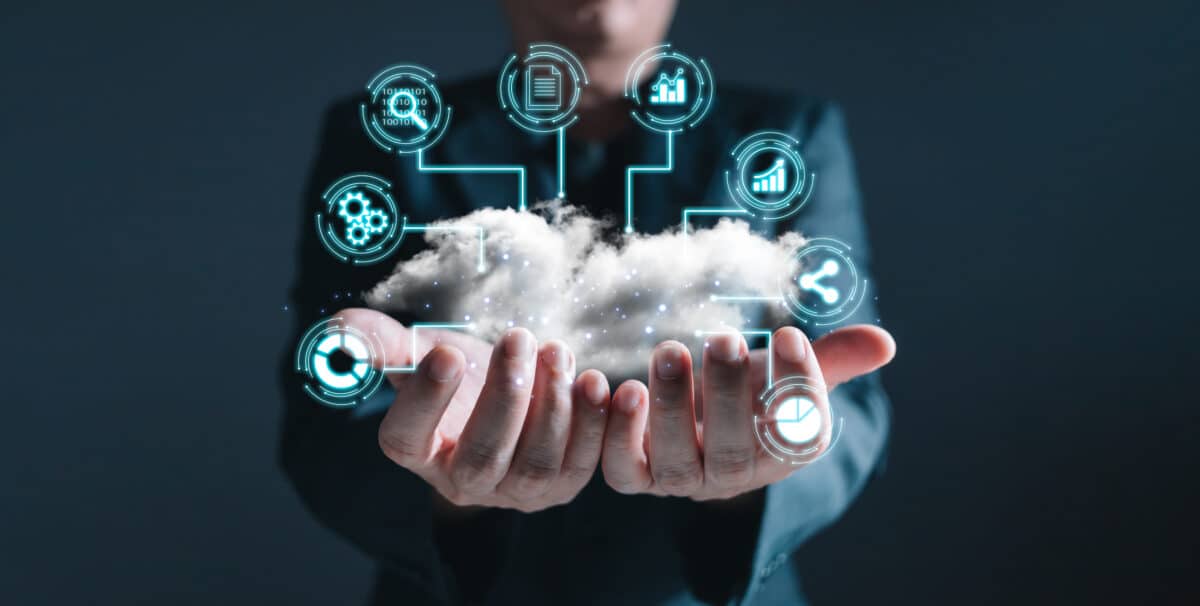 Person holding hands out with a large puffy cloud and digital images to represent cloud storage